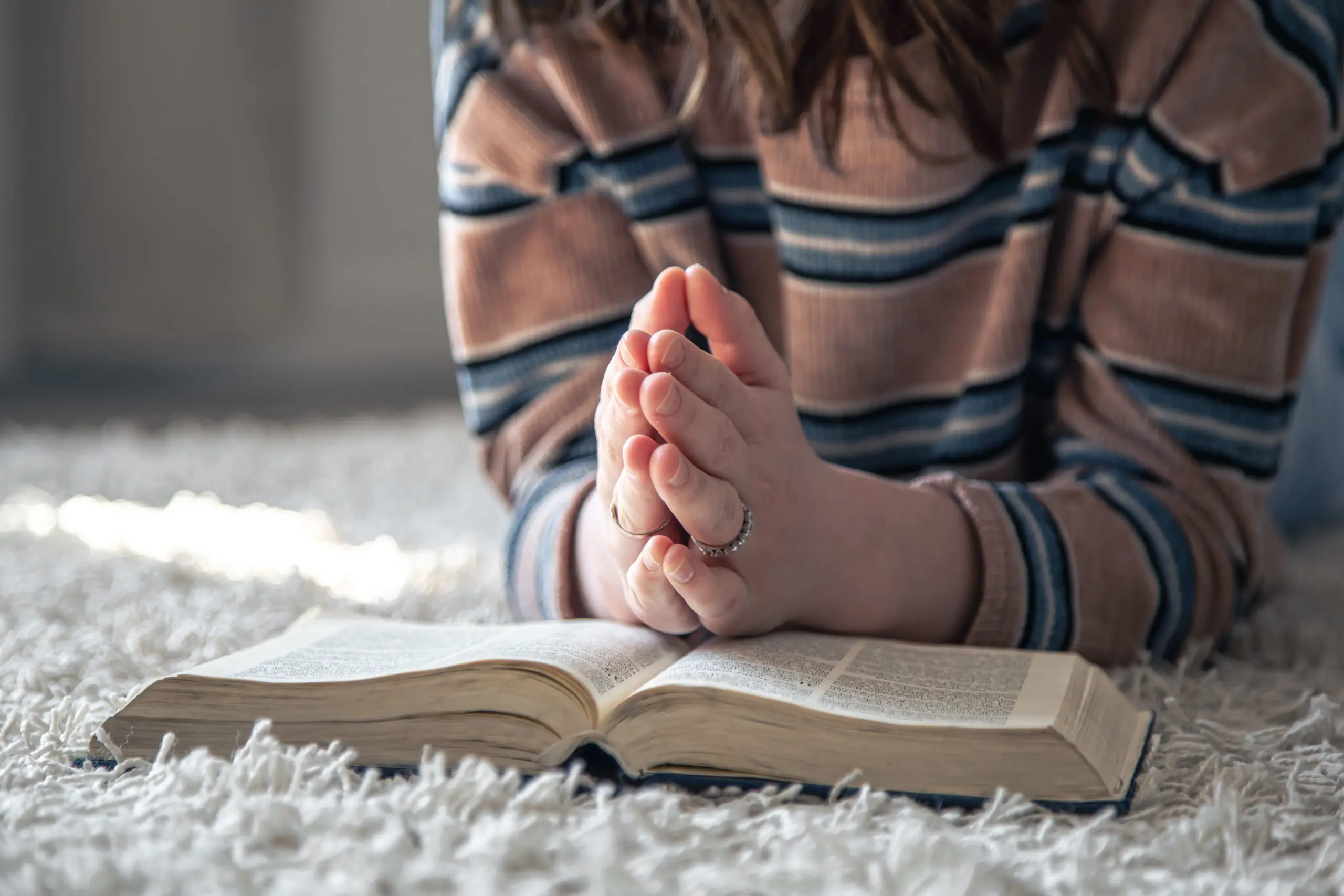 a-young-woman-is-reading-the-bible-while-lying-on-2022-04-07-20-30-57-utc-scaled-1